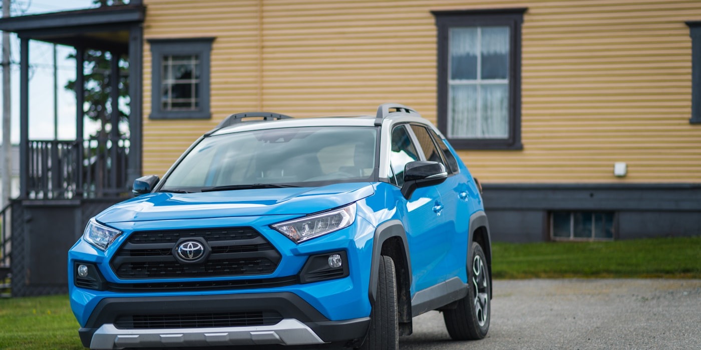蓝色 Toyota RAV4 紧凑型 SUV 停在住宅前